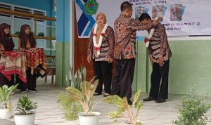 guru Mengapresiasi: Acmad Fauzi, Kepala SDN Dempo Barat 2 mengalungkan bunga Kepada Guru Penggiat Literasi