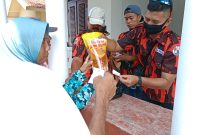 JUALBELI: Salah satu warga saat mengunjungi stand pasar  murah minyak goreng yang diadakan oleh Pemuda Pancasila Pulau Sapudi Sumenep, Sabtu, 05 Februari 2022/Foto Masudi for Lensa Madura.